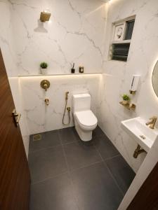 a white bathroom with a toilet and a sink at Keerthis Grand Hotel near Kempegowda International Airport in Bangalore +19 photos