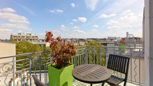 a balcony with a table and a vase with a plant at Campanile Prime - Paris 14 Maine Montparnasse in Paris