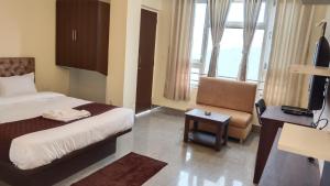 a hotel room with a bed and a chair at The Bliss Hotel and Restaurant in Gangtok +6 photos