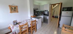 a kitchen with a table and a refrigerator at MV Vacances in Les Rousses