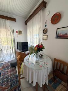 a room with a table with a vase of flowers on it at Domi's Cottage in Agia Triada
