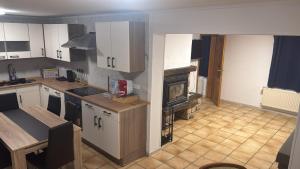 a kitchen with a stove and a fireplace in it at Haus in Roth an der Our in Roth +5 photos