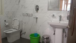 a white bathroom with a sink and a toilet at The Bliss Hotel and Restaurant in Gangtok