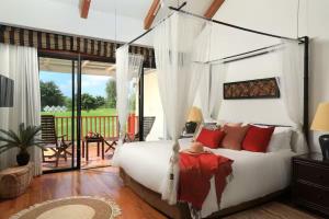 a bedroom with a large white bed with red pillows at Laguna Fairway 3B villa-golf view in Laguna Phuket