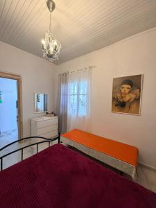 a bedroom with two beds and a chandelier at Domi's Cottage in Agia Triada