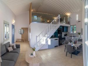 a living room and kitchen with a staircase in a house at Remetzo Village in Lixouri