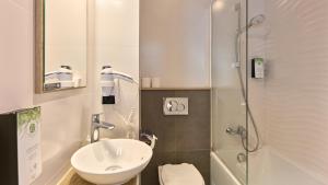 a small bathroom with a sink and a shower at Campanile Prime - Paris 14 Maine Montparnasse in Paris +15 photos