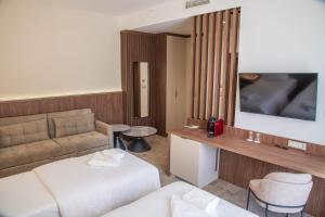 a hotel room with a bed and a couch at Hotel Onogošt in Nikšić