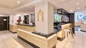 a bar in a restaurant with a counter at Campanile Prime - Paris 14 Maine Montparnasse in Paris