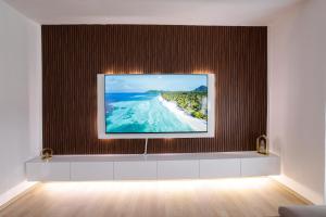 a tv on a wall with a picture of a beach at Premium Stay Prishtina in Prishtinë +21 photos