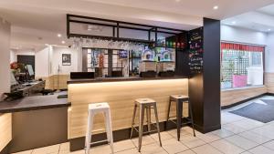 a bar in a restaurant with stools at Campanile Prime - Paris 14 Maine Montparnasse in Paris
