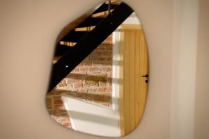 a mirror on a wall next to a staircase at Sedlářský dům in Kunratice