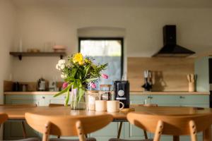 a kitchen with a table with a vase of flowers on it at Sedlářský dům in Kunratice