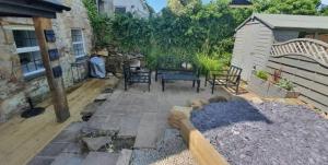 a patio with chairs and a table and a building at The Annexe At The Old Mill in Camborne