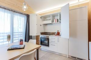 a kitchen with white cabinets and a table with chairs at Baita sulle piste in Valmalenco in Chiesa in Valmalenco
