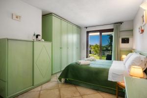 a bedroom with green cabinets and a bed and a window at Sardegna è - Beach Rooms LE in Olbia