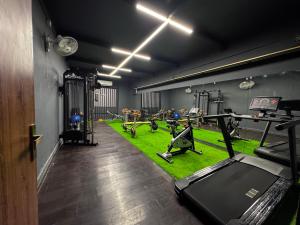 a gym with treadmills and machines in a room at Pink Villa Boutique Hotel in Meerut