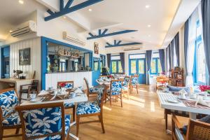a restaurant with tables and chairs and windows at Somewhere Koh Sichang in Ko Si Chang +46 photos