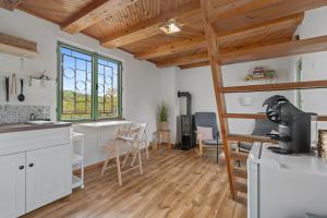 a kitchen with white cabinets and wooden ceilings at Chata obklopena přírodou in Malé Žernoseky