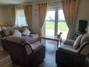 a living room with two couches and a table at Ocean View in Quilty