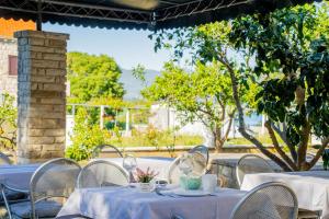 a group of tables with white table cloths on them at Pansion Marinka-Bire Rooms in Lumbarda