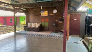 a living room with a couch on a porch at Hotel O Green Desa Bayu in Kota