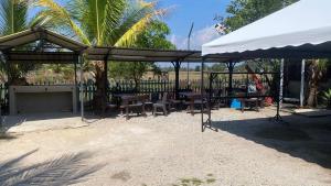 a picnic shelter with tables and chairs in a park at Hotel O Green Desa Bayu in Kota