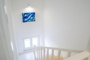a white staircase with a painting on the wall at Pansion Marinka-Bire Rooms in Lumbarda