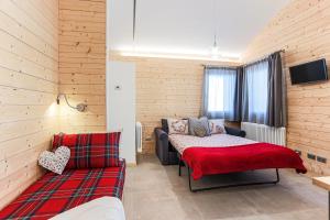 a room with a bed and a couch and a tv at Baita sulle piste in Valmalenco in Chiesa in Valmalenco