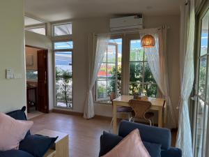 a living room with a table and some windows at De 8 Huahin in Ban Nong Chaeng