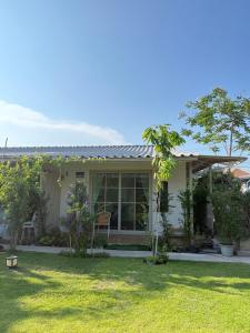 a small white house with a green yard at De 8 Huahin in Ban Nong Chaeng