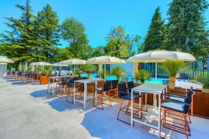 a row of tables and chairs with umbrellas at Hotel Alkar - Family Friendly Hotel with Pool in Sinj, Dalmatia in Sinj