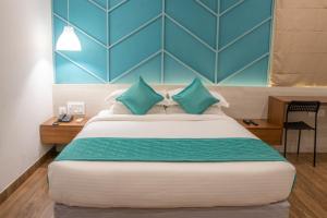 a bedroom with a large bed with blue walls at YC Grand Mystic Premier, Electronic City in Bangalore