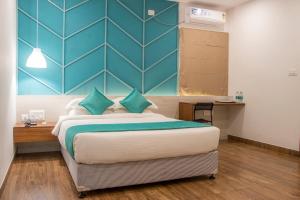 a bedroom with a large bed with a blue wall at YC Grand Mystic Premier, Electronic City in Bangalore