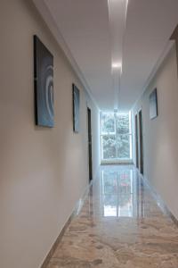 an empty hallway with paintings on the walls and a window at YC Grand Mystic Premier, Electronic City in Bangalore +19 photos