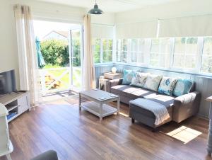 a living room with a couch and a tv at Hydaway in Bacton