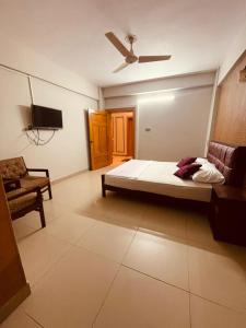 a bedroom with a bed and a couch and a ceiling fan at Solo Hotel in Sargodha