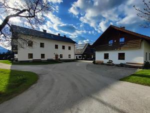 a large white house with a driveway at Bio-Ferienhof Hotz in Spital am Pyhrn