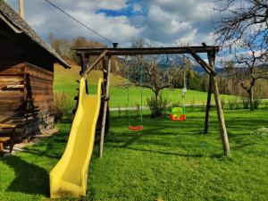 a playground with a yellow slide in a field at Bio-Ferienhof Hotz in Spital am Pyhrn