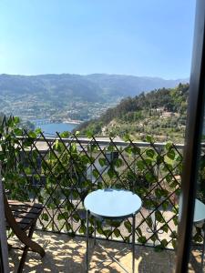 a table and chairs on a balcony with a view at Casa da Laija - Vistas rio - "Gerês" in Geres