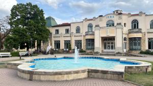 a large building with a fountain in front of it at Tanny Boho Housy na pešej zóne in Piešťany
