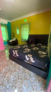 a bedroom with a large bed and a couch at Hotel O Green Desa Bayu in Kota