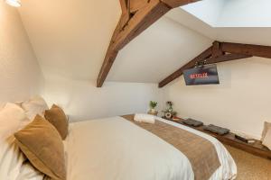 a bedroom with a bed and a tv on the wall at Le splendide - modern & cocooning in Tarbes