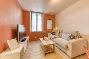 a living room with a couch and a tv at Le splendide - modern & cocooning in Tarbes