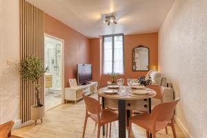 a living room with a table with chairs and a tv at Le splendide - modern & cocooning in Tarbes