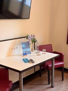 a table with chairs and a vase of flowers on it at Schlüter Hotel & Restaurant in Wankendorf