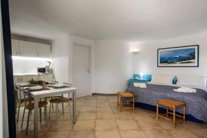 a bedroom with a bed and a table and chairs at Sardegna è - Beach Rooms LE in Olbia