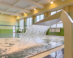 a water fountain in the middle of a swimming pool at Łazienki Uzdrowiskowe Nr 1 in Ciechocinek