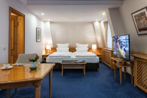 a hotel room with a bed and a tv at Waldhaus Reinbek in Reinbek +42 photos
