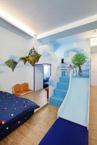a bedroom with a blue bed and a mural of clouds at 維邇莊園-Weir manor 傑克堡 in Tainan
